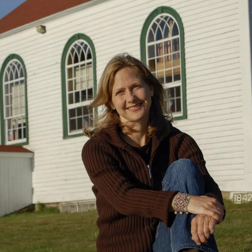 Suzie LeBlanc à l'extérieur devant une petite église en bois